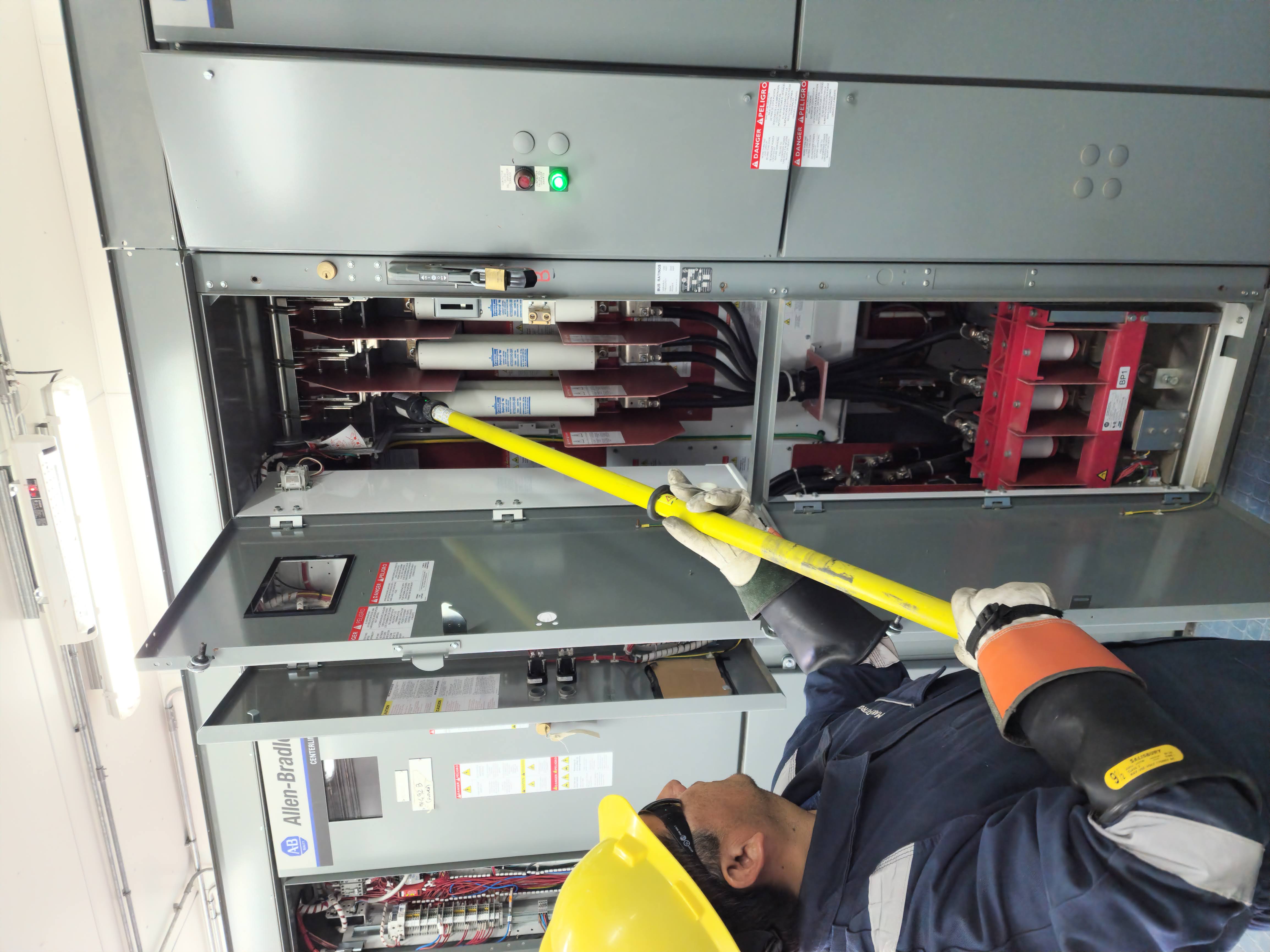 Trabajador inspeccionando tablero eléctrico industrial